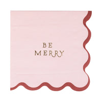 Close-up of the single light pink scalloped edge Christmas napkin with gold foil text.