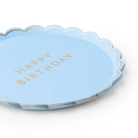 Side view of a stack of sky blue paper plates with gold foil lettering and scalloped edges.