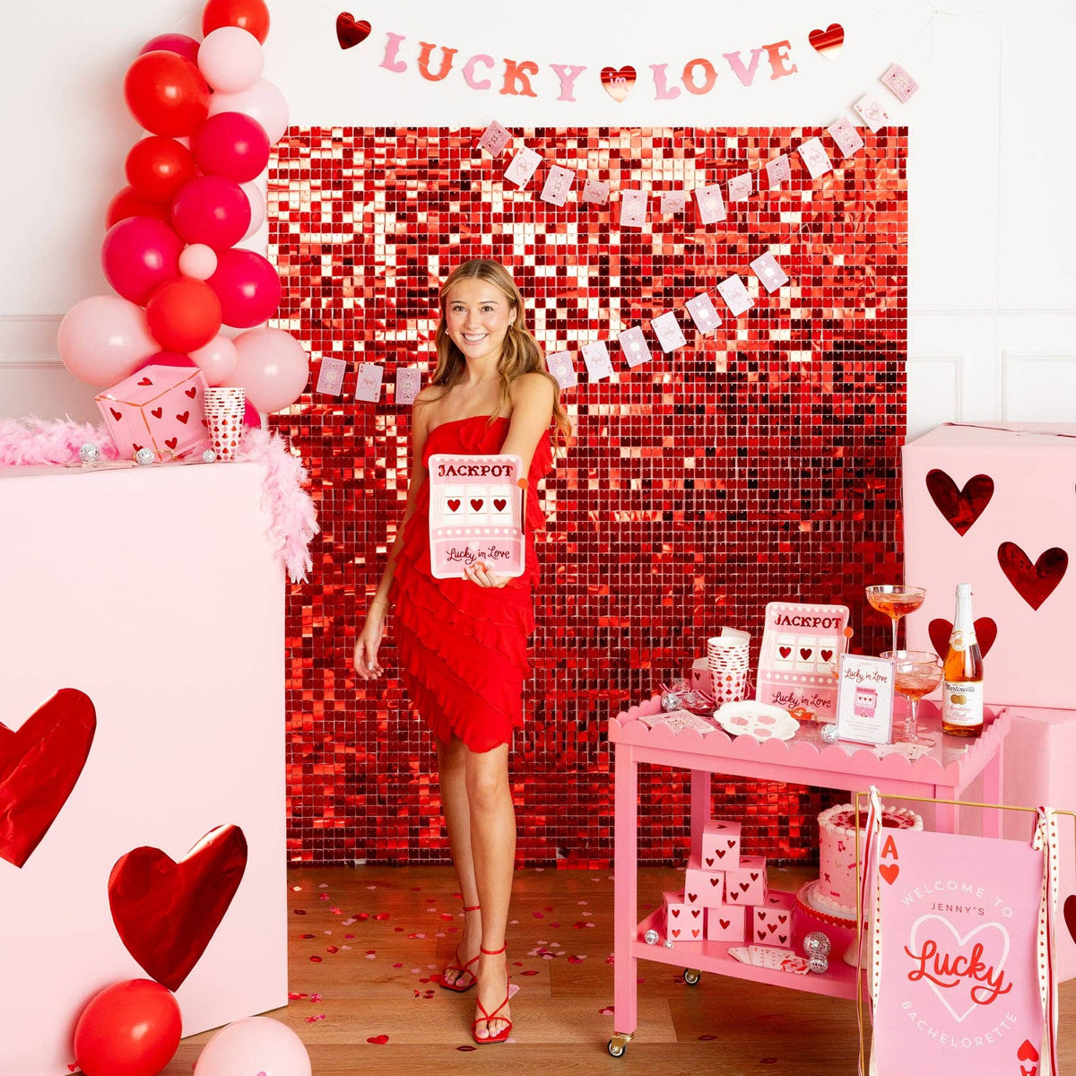 Woman holding slot machine plate at a red and pink themed event.