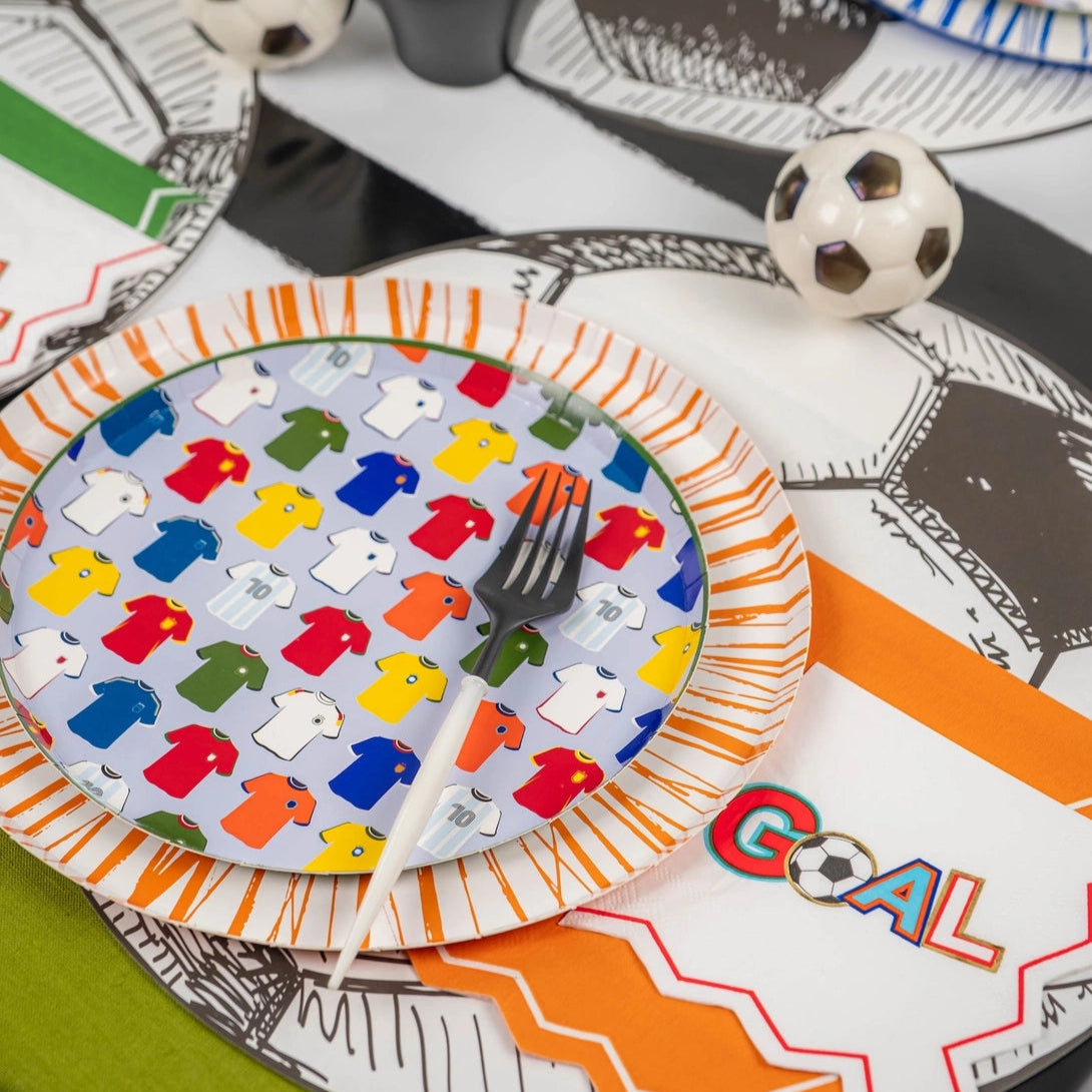 Orange-rim plate close with GOAL napkin and soccer runner