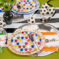 Two jersey place settings with blue and orange rims on soccer-mat runner