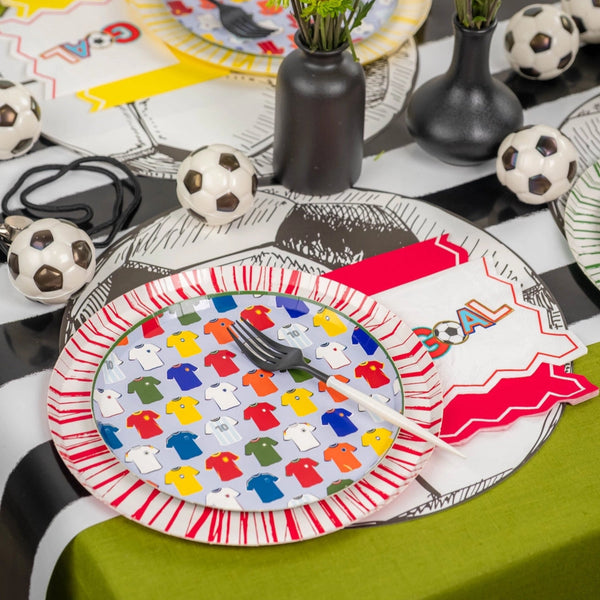 Table with yellow-rim plate, vases, and GOAL napkins