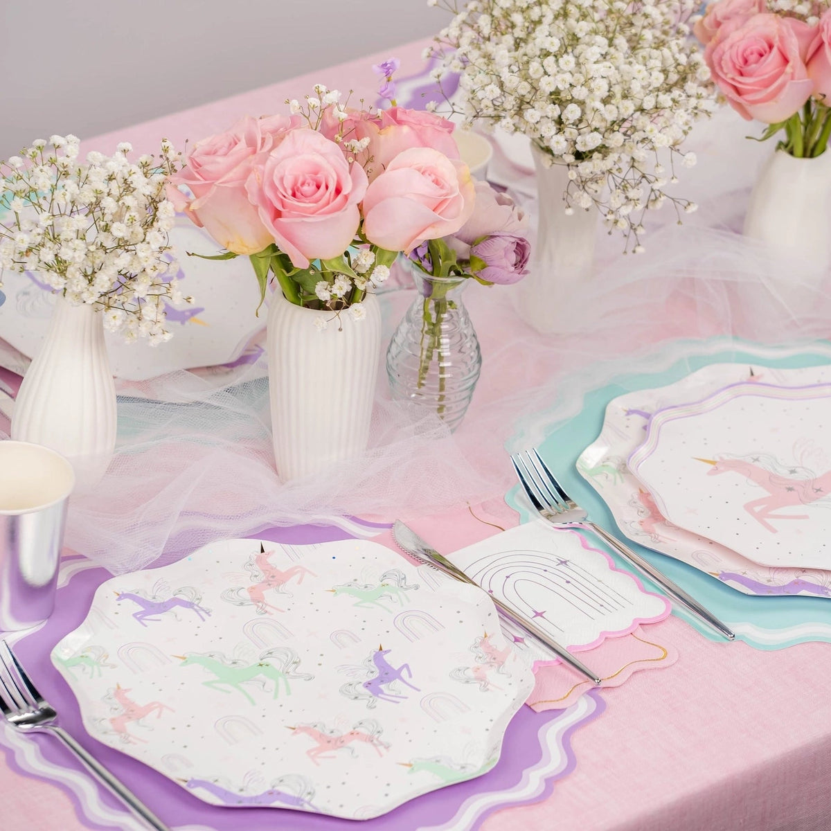 Pastel unicorn tablescape with sparkle rainbow beverage napkins at each setting—perfect for a unicorn birthday party.