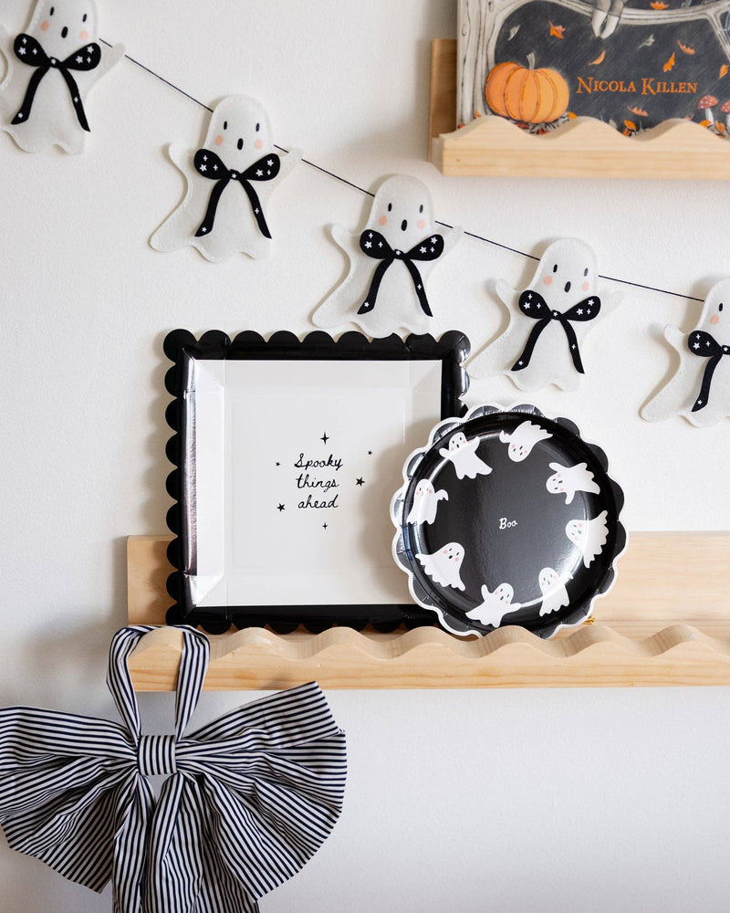 Halloween-themed decor featuring Spooky things ahead paper plate with other ghost decorations.
