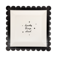 Cream scalloped paper plate with black "SPOOKY THINGS AHEAD" text and a black scalloped edge, front view.