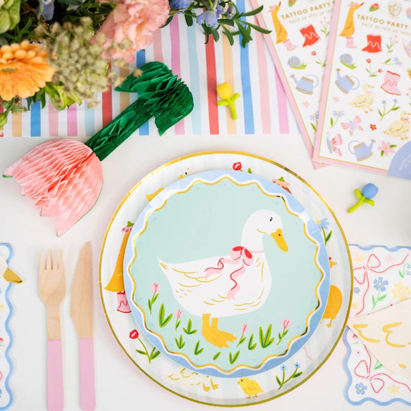 Close-up of pastel honeycomb tulip decoration next to Easter tableware and spring accents