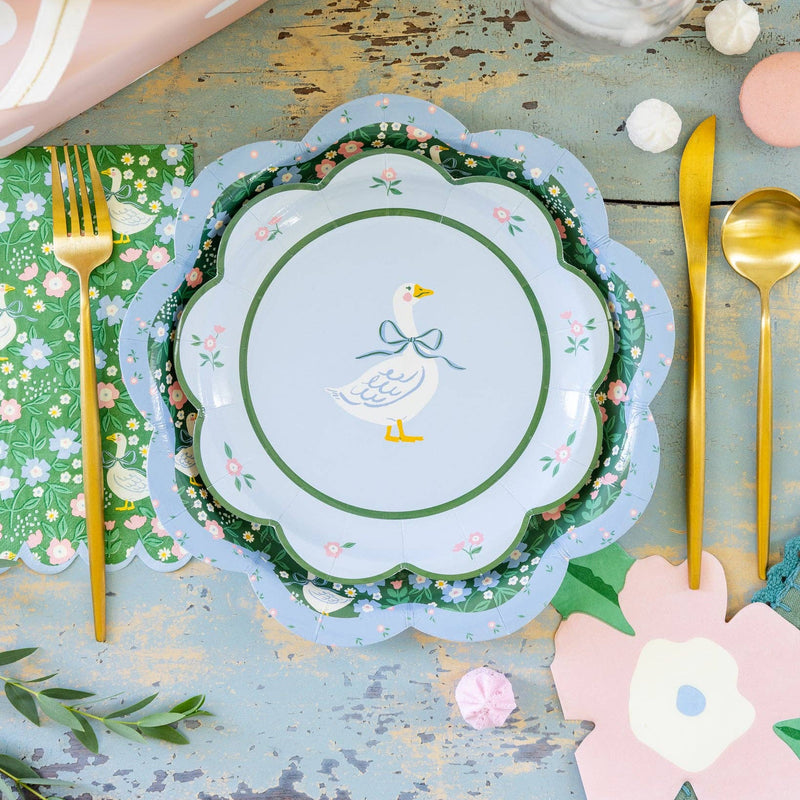 Spring table setting with floral plates and pink flower napkins for garden party