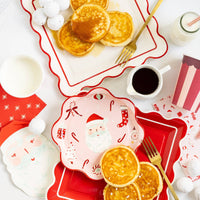 Santa napkin styled on holiday breakfast table with pancakes and red plates