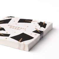 Stack of graduation lunch napkins with black caps and gold foil tassels