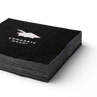 Stack of black graduation cocktail napkins with cap graphic