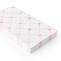 Stacked paper guest towels featuring a pink trellis pattern with gold bow details.