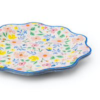 Stack of multicolor floral paper dinner plates with scalloped edges.