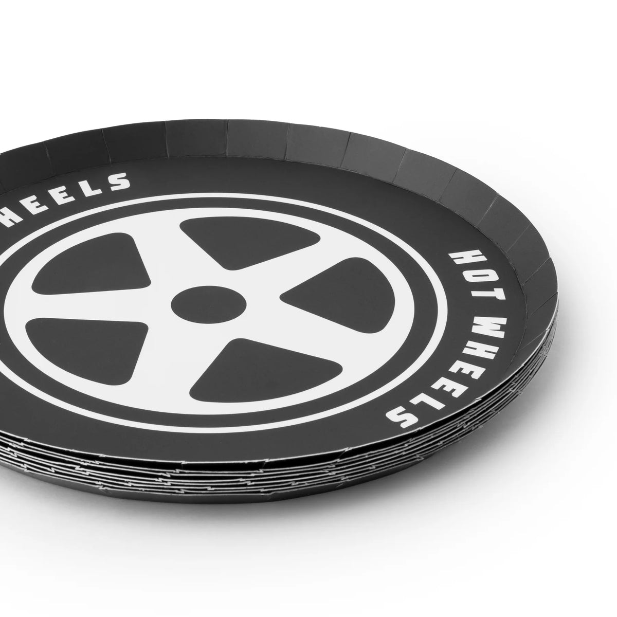 Stacked set of tire dessert plates showing the black color and white tire pattern repeating on the edge.