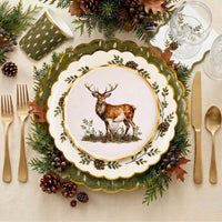 Woodland place setting with the stag plate on a pinecone plate and olive charger, gold cutlery, pinecones, and evergreen.