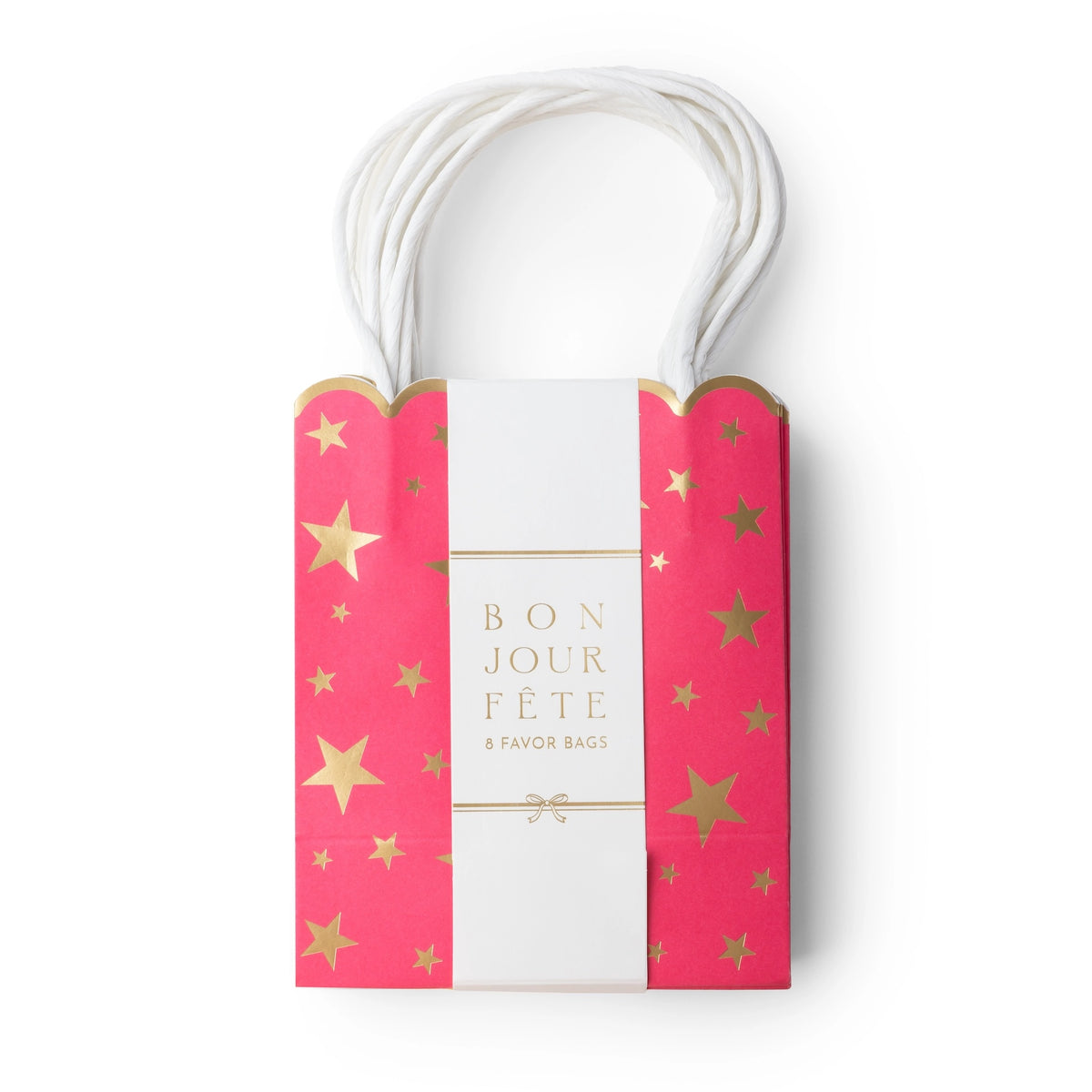 Pink gold-star favor bag wrapped in a white Bonjour Fête belly band, showing the scalloped top and paper handles.