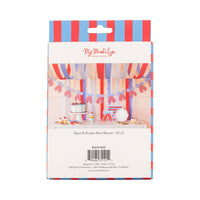 Back of retail packaging for stars and stripes bow banner showing styled dessert table photo, blue and red striped border, and product details