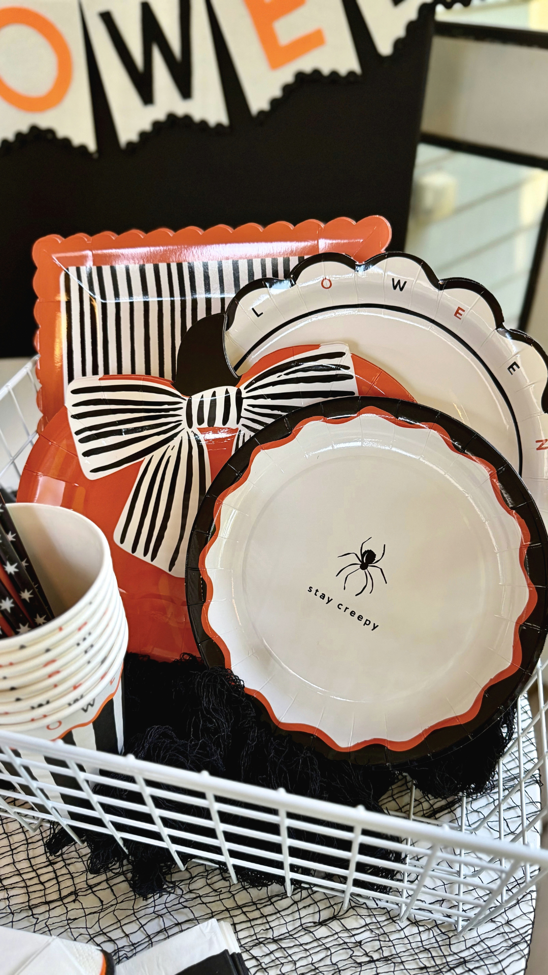 Scalloped white Halloween paper plates with a black edge and black and orange letters spelling Halloween around the rim