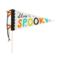 Clean product-on-white: the full "Stay Spooky" felt pennant on its wood dowel, cream triangle with black scalloped binding and black-and-cream striped plus black grosgrain ribbons; "Stay" in black script and "SPOOKY" in orange, teal, chartreuse, and black felt letters with moon and star accents. Side-on hero shot.