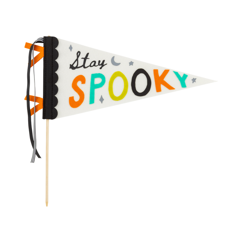 Clean product-on-white: the full "Stay Spooky" felt pennant on its wood dowel, cream triangle with black scalloped binding and black-and-cream striped plus black grosgrain ribbons; "Stay" in black script and "SPOOKY" in orange, teal, chartreuse, and black felt letters with moon and star accents. Side-on hero shot.