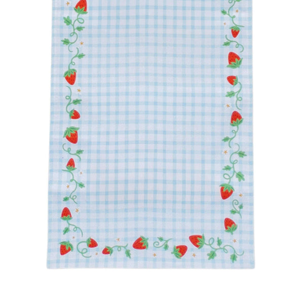 Close-up corner of the strawberry gingham table runner showing red berries, curling green vines, and tiny gold stars along the blue gingham edge.