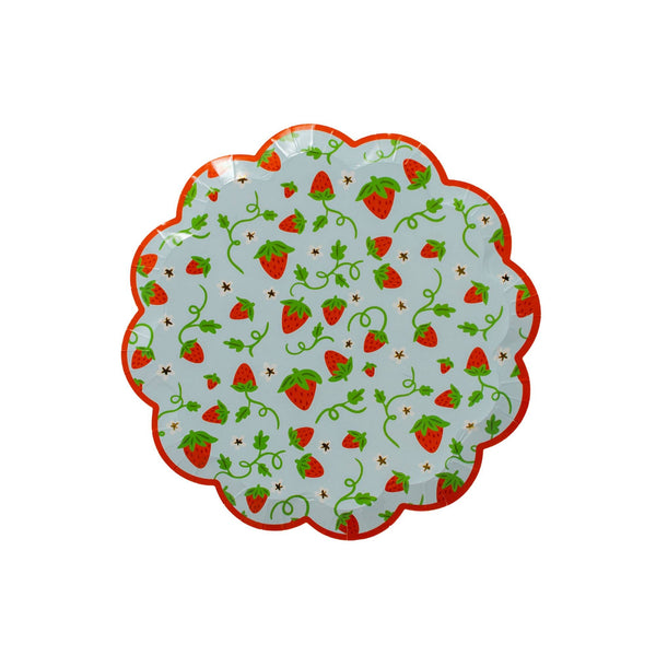 Single strawberry scalloped paper dessert plate on a white background showing the wavy red scalloped edge, pale blue base, and scattered red strawberries with green vines, tiny daisies, and gold star accents