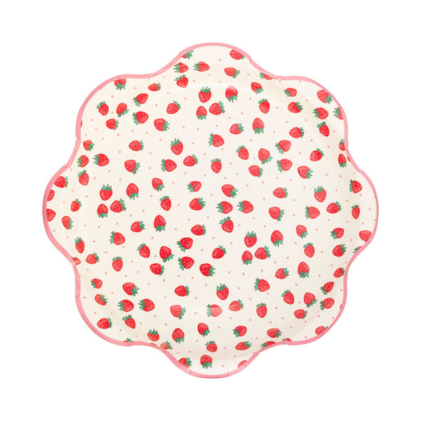 Single Strawberry Scalloped Paper Dinner Plate on white background showing cream surface scattered with red strawberries with green leafy stems and small pink polka dots, framed by a pink scalloped flower-shaped border