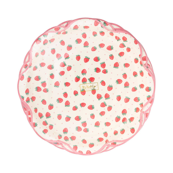 Top-down view of stack of Strawberry Scalloped Paper Dinner Plates showing cream background with all-over red strawberry print with green stems and tiny pink polka dots, finished with a pink scalloped flower-shaped edge