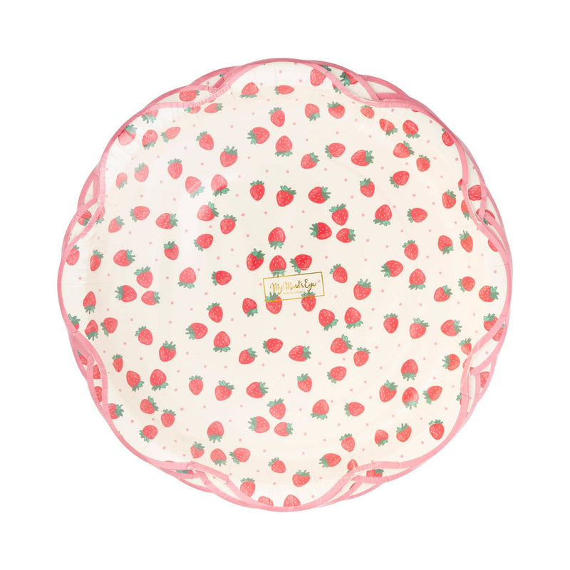 Top-down view of stack of Strawberry Scalloped Paper Dinner Plates showing cream background with all-over red strawberry print with green stems and tiny pink polka dots, finished with a pink scalloped flower-shaped edge
