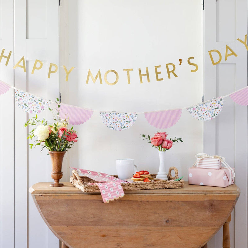 Spring brunch table styled with striped floral napkins and Happy Mother’s Day banner