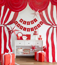 Styled room with the striped napkins on a console against a red-and-white striped curtain with a party banner.