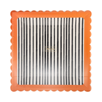 Angled view of the striped square Halloween plate showing the black-and-cream vertical stripes and orange scalloped edge detail, packaged top view.