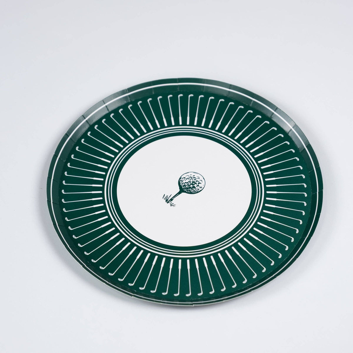 An angled perspective of a sturdy paper golf party plate showing the depth and high-quality finish of the clubhouse-themed dinnerware on a clean white background.