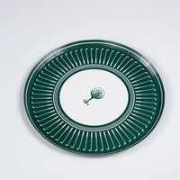 An angled perspective of a sturdy paper golf party plate showing the depth and high-quality finish of the clubhouse-themed dinnerware on a clean white background.