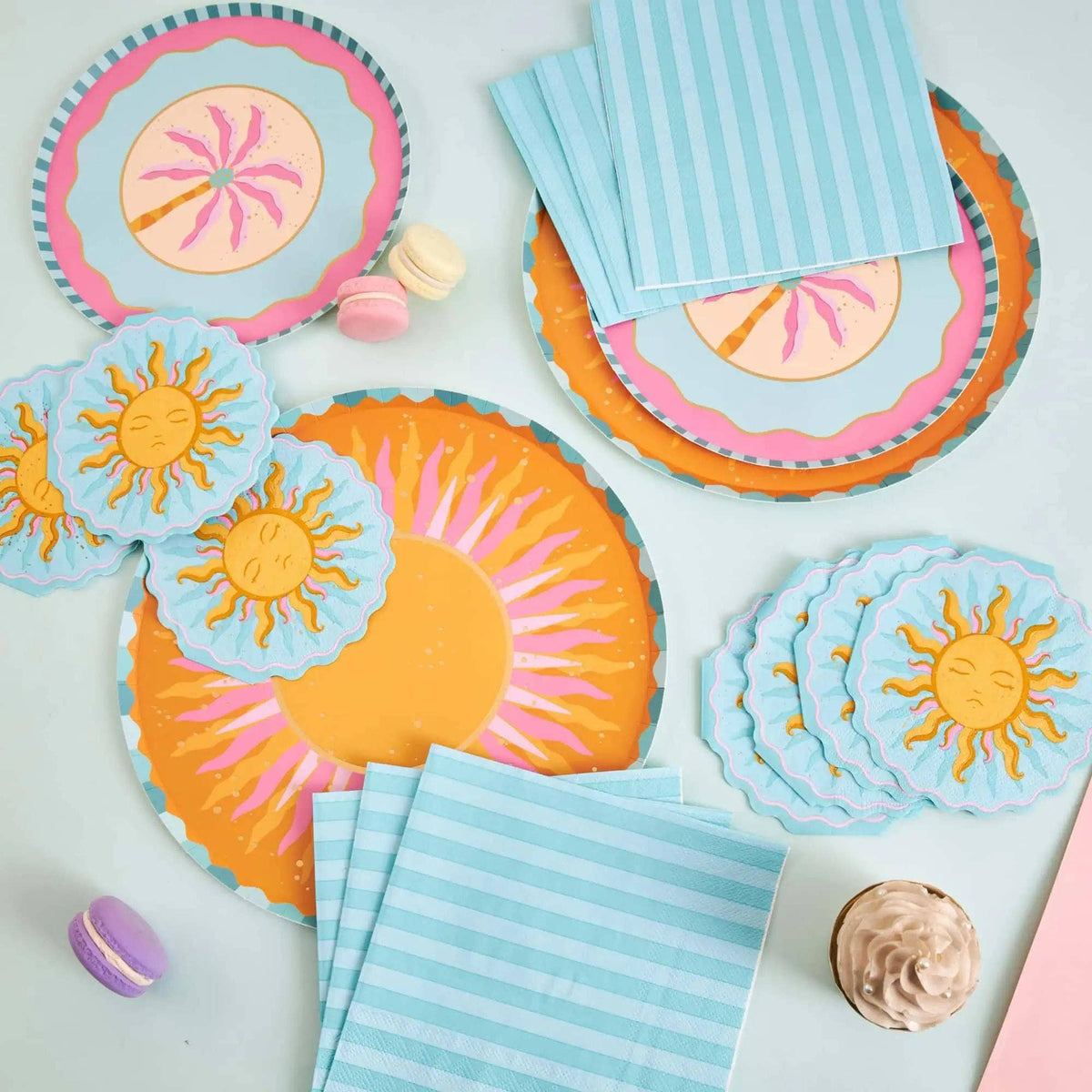 Sun collection spread with a large sunburst plate, sun-shaped napkins, a palm plate, and blue striped napkins.