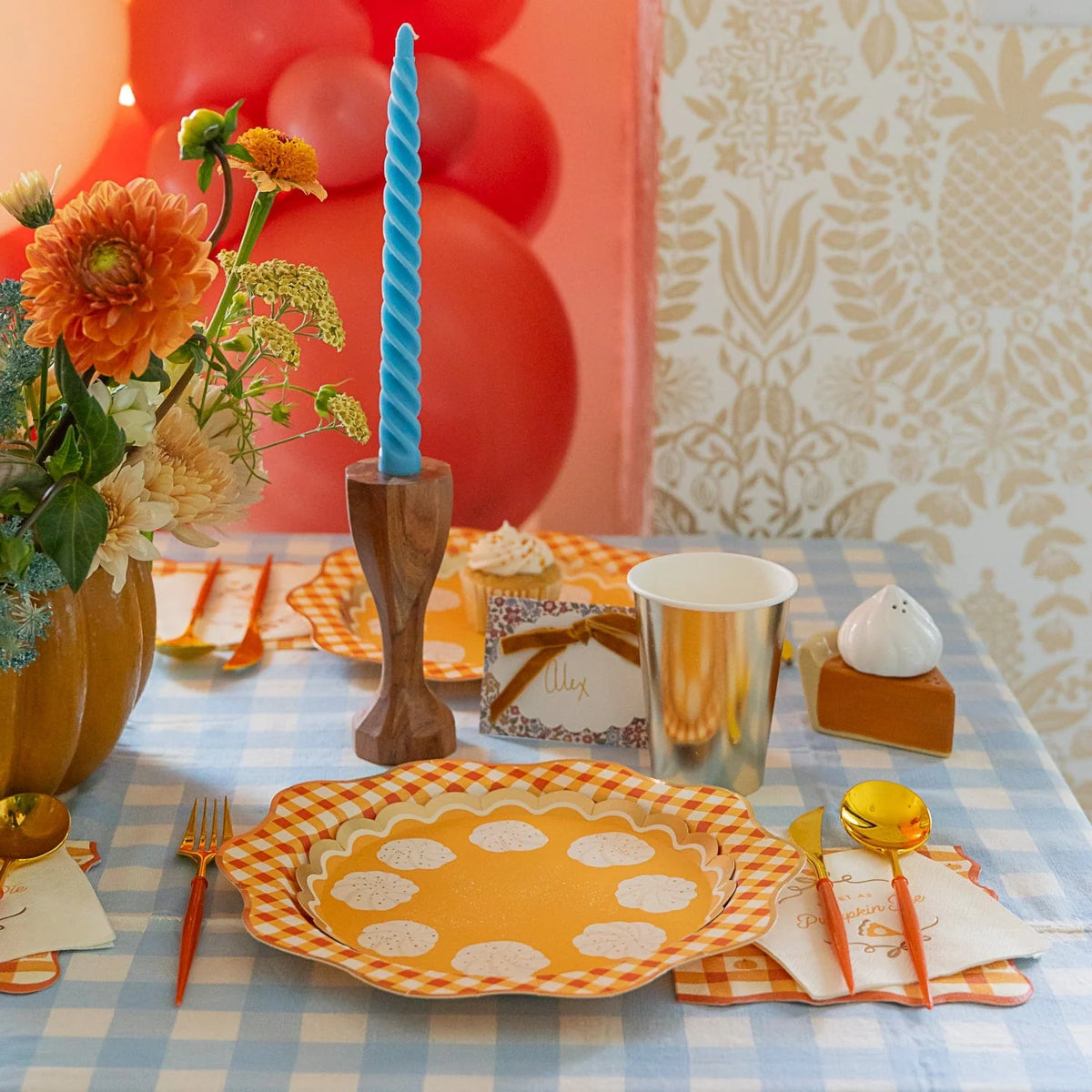 Fall tablescape with gingham plates, gold cups, and paper cocktail napkins reading “Sweet as Pumpkin Pie.”