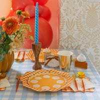 Fall tablescape with gingham plates, gold cups, and paper cocktail napkins reading “Sweet as Pumpkin Pie.”