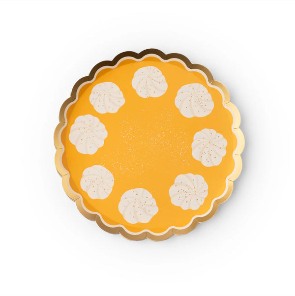 Isolated front view of the round pumpkin pie plate with dollops around the edge.