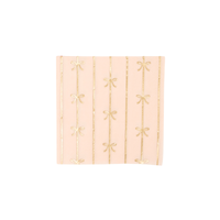 Soft peach cocktail napkin with vertical gold foil bow accents
