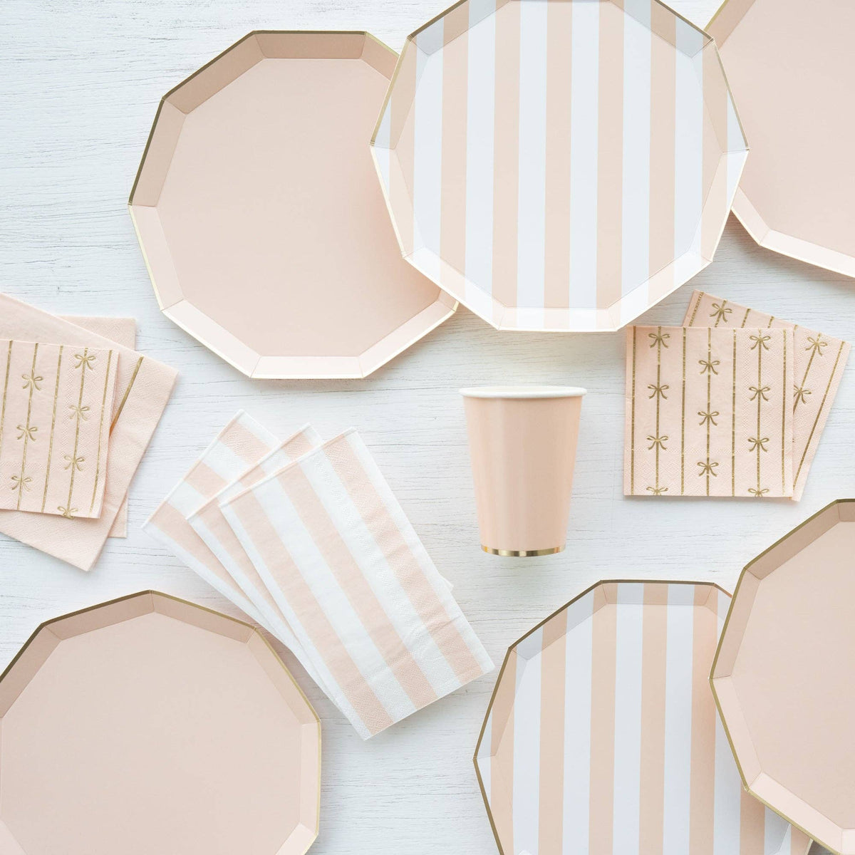Sweet Peach napkins styled with matching plates, cups, and bow napkins in peach and gold tablescape setup