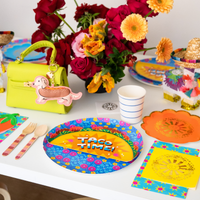 taco themed party table with taco plate flowers and colorful fiesta decorations
