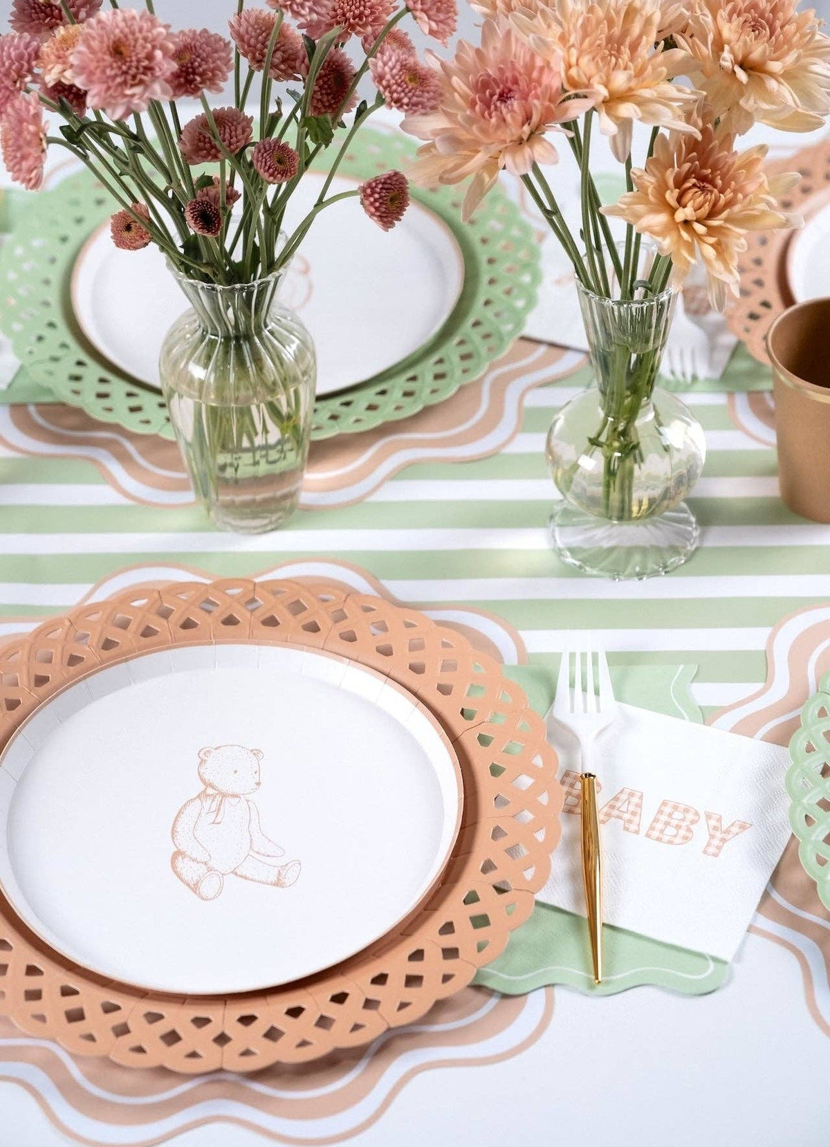 Tan gingham BABY napkin on a neutral baby shower table with peach and rose chrysanthemums in glass vases