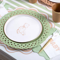 Tan gingham BABY napkin beside a teddy bear plate on a sage green lattice charger with a gold fork