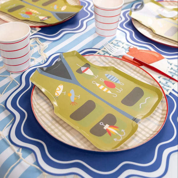 Tan plaid base plate under a fishing vest shaped plate with striped cups on a wavy placemat.