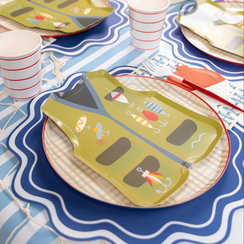 Tan plaid base plate under a fishing vest shaped plate with striped cups on a wavy placemat.