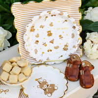 Tan striped plates styled with baby shower desserts and neutral table decor