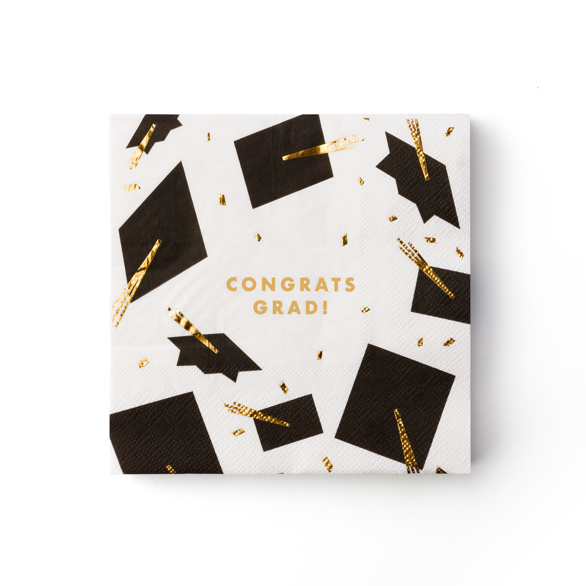 White graduation lunch napkin with black caps and gold tassels saying “Congrats Grad”