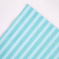 Angled corner detail of teal striped paper napkin
