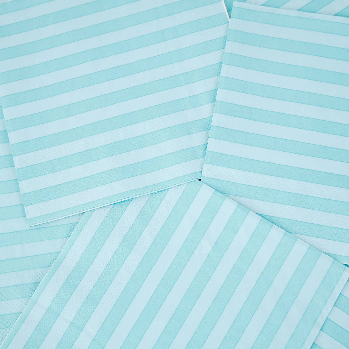 Close-up of overlapping teal striped paper lunch napkins