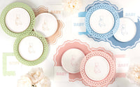Green, tan, blue, and pink teddy bear paper plates laid out together with matching BABY napkins