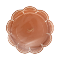 Front-facing studio shot highlighting the glossy finish and deep scalloped rim of the solid rust paper dinner plate.